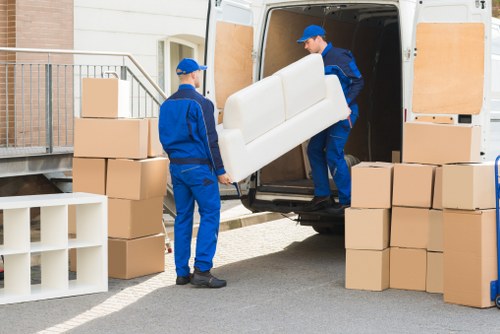 Professional mover carrying household items near a Haringey flat
