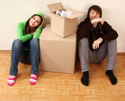 Removal workers using safe manual handling and securing items for transport