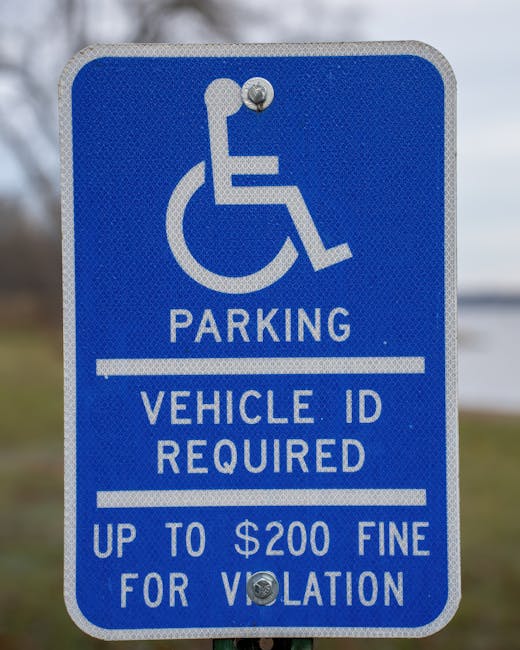 A close-up of a blue parking sign with a white wheelchair symbol indicating accessible parking, mounted on a metal post against a partly cloudy sky background. The sign includes the text 'PARKING' at the top, followed by a line, then 'VEHICLE ID REQUIRED,' another line, and a notice of a fine of up to $200 for violations below. The sign is positioned near a residential or commercial property, with a tiled surface or pavement at its base. This image relates to house removals and logistics, as indicated by the context of Tottenham Hale removals vans access and lift restrictions, with [COMPANY_NAME] providing professional moving and furniture transport services, ensuring compliance with local parking regulations during home relocation or furniture transportation tasks.